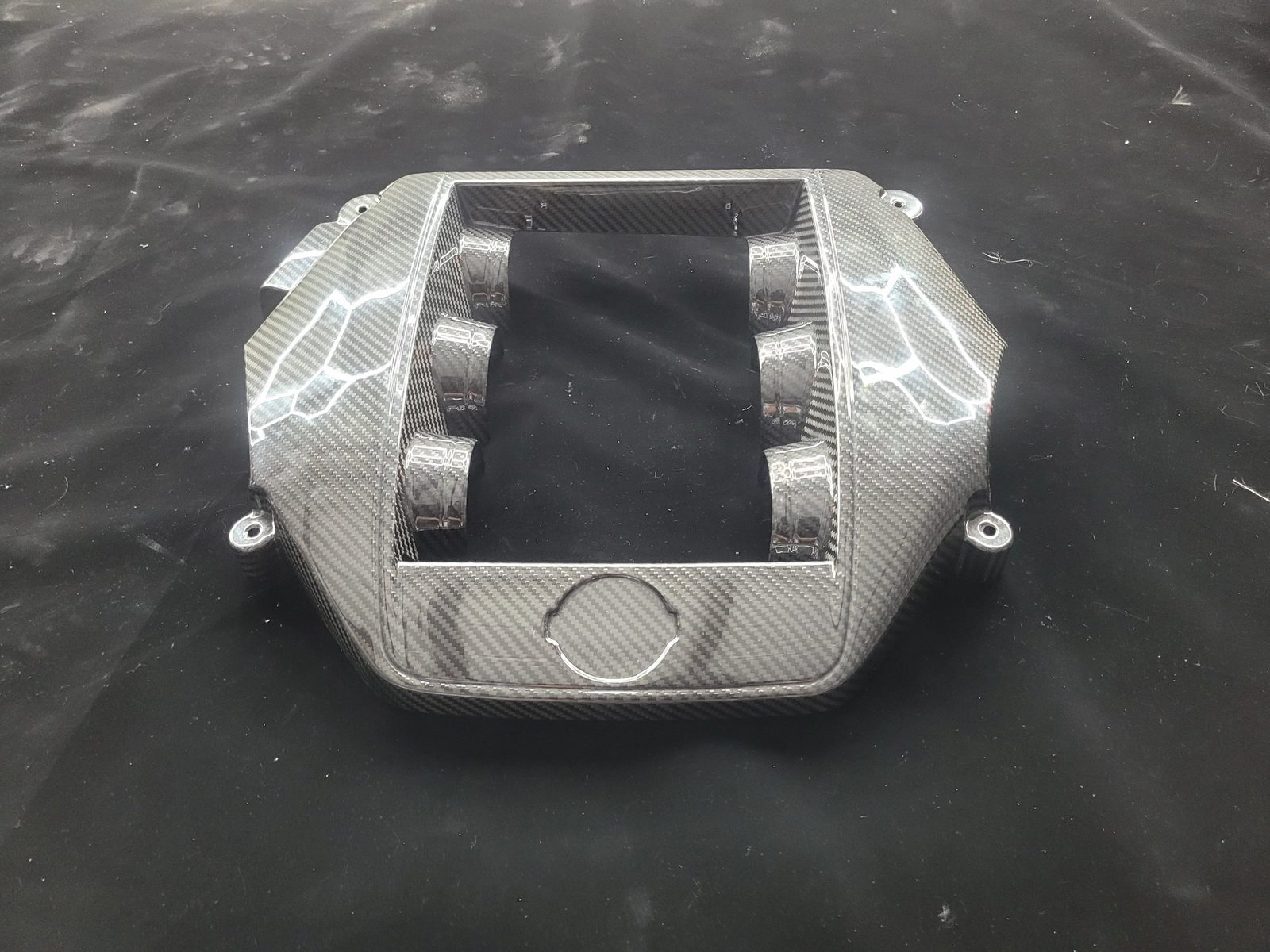 Custom carbon fiber engine cover for a Nissan R35 GT-R with six intake runner openings and hex-pattern gloss finish