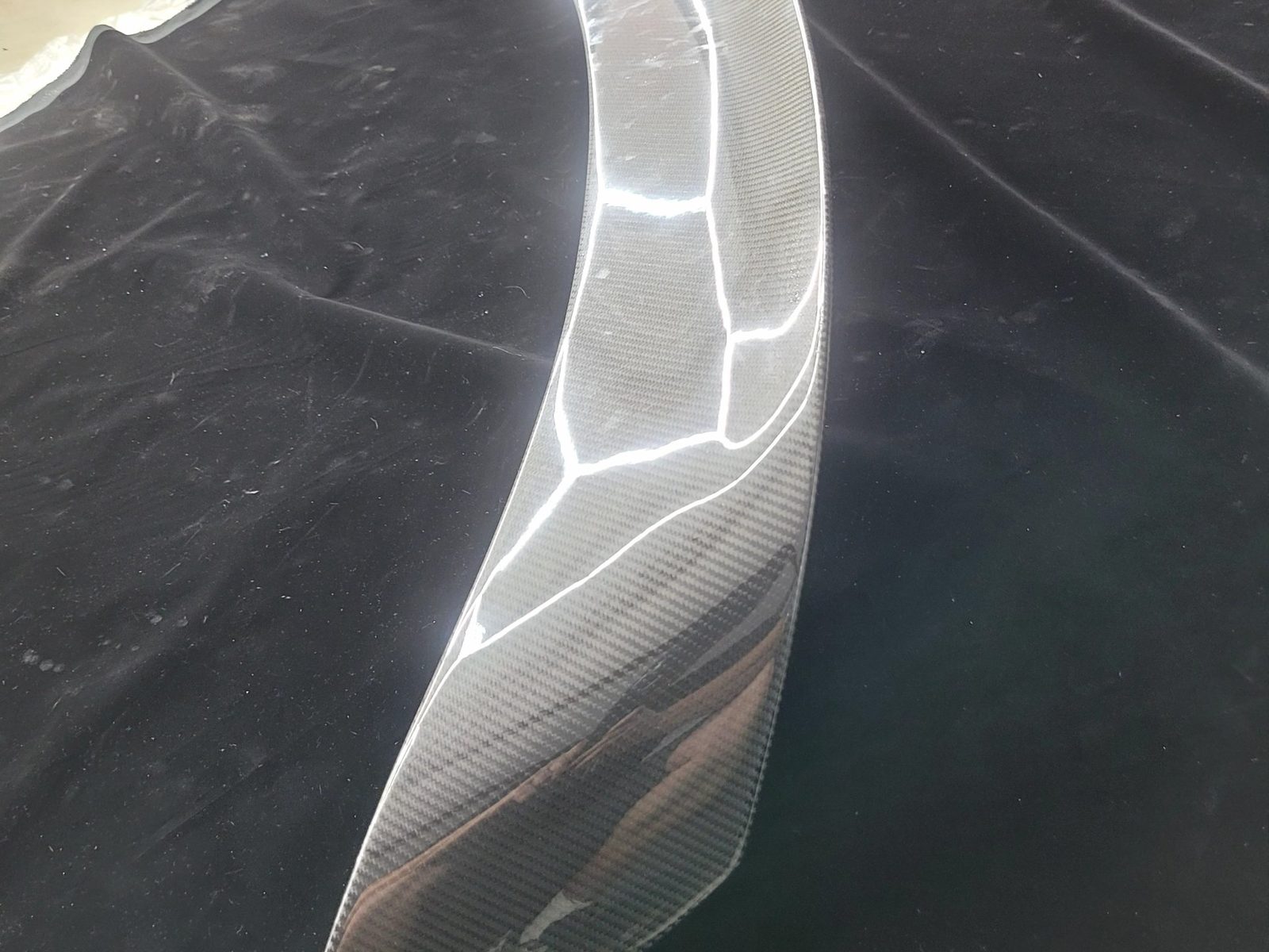 Twill-weave carbon fiber spoiler for a 2015 Roush Mustang, angled view showing gloss clear coat